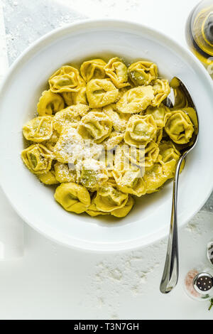 Platte der italienischen Ravioli mit Parmesan auf der Platte der italienischen zubereitet ravioli Tortellini mit Parmesan Käse auf dem Tisch. Gesunde mediterrane Stockfoto