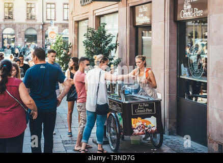 Straßburg, Frankreich, 22.Juli 2017: junge blonde Frau mit Kunden mit französischen Bio home-made Eisdiele im Zentrum von Straßburg Frankreich Bild horizontal Stockfoto