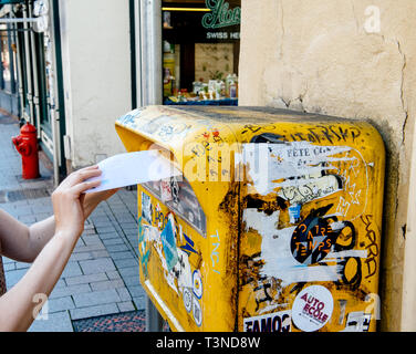 Straßburg, Frankreich, 22.Juli 2017: Seitenansicht des Frau Hand einfügen einen Brief in öffentliche Mailbox mit mehreren Aufkleber in City Center abgedeckt Stockfoto