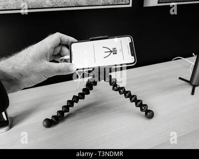 Paris, Frankreich, 19.März 2019: POV Mann hält das iPhone XS auf dem Joby Gorillapod auf dem Zubehör Stativ im minimalistischen Stil und Luxus Design der Apple Store Champs-Elysees größte französische Store - Schwarz und whtie Stockfoto