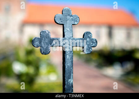 Vechta, Deutschland. 09 Apr, 2019. Ein Kreuz am Eisernen Tor auf dem Friedhof der St. Mary's Kirche in der Oythe Bezirk. Credit: Hauke-Christian Dittrich/dpa/Alamy leben Nachrichten Stockfoto