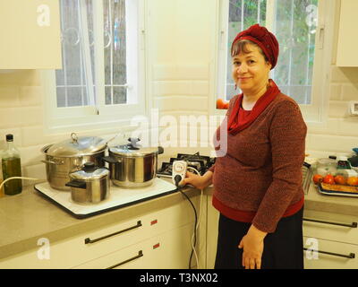 Tel Aviv, Israel. 04 Mär, 2019. Moria Seira steht neben einem wärmenden Platte mit Töpfen, mit der die religiösen Jüdin hält das Essen warm am Sabbat. Der Timer wird vor dem Sabbat und Schalter Ein- und Ausschalten entsprechend programmiert. Die Familie lebt im Zentrum von Tel Aviv und hält den Sabbat. Dies beinhaltet auch nicht schalten Sie elektrische Geräte ein- oder ausschalten. (Zu dpa Nordischem: Wie Juden Befolgen der Gebote Gottes mit moderner Technik") Credit: Stefanie Järkel/dpa/Alamy leben Nachrichten Stockfoto