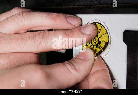 Hannover, Deutschland. 10 Apr, 2019. Eine TÜV Nord Mitarbeiter klebt eine TÜV-Plakette auf dem Nummernschild während einer HU Hauptuntersuchung. Credit: Julian Stratenschulte/dpa/Alamy leben Nachrichten Stockfoto