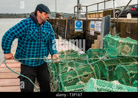 Schull, West Cork, Irland. 11 Apr, 2019. Ein einheimischer Fischer bereitet seine Krabbe Töpfe vor dem Laden auf seinem Boot für eine Angeltour heute später. Das Wetter ist kalt, aber trocken, mit der Sonne beginnt ein Aussehen zu machen. Der Tag bleibt weitgehend trocken mit Temperaturen von 11 bis 15°C. Credit: Andy Gibson/Alamy leben Nachrichten Stockfoto