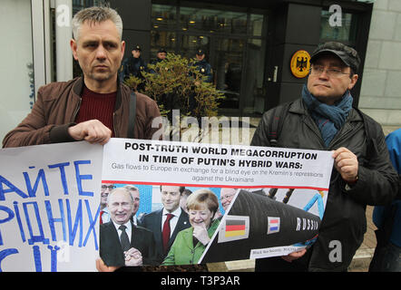 Kiew, Kiew, Ukraine. 11 Apr, 2019. Aktivisten gesehen Holding ein Poster mit Fotos des russischen Präsidenten Wladimir Putin und die deutsche Bundeskanzlerin Angela Merkel während der Rallye. Vereinigung der Angehörigen der politischen Gefangenen des Kreml und Angehörigen der ukrainischen Kriegsgefangenen eine Kundgebung gegen die Aufhebung der Sanktionen gegen die Russische Föderation vor der deutschen Botschaft in Kiew statt. Credit: Pavlo Gontschar/SOPA Images/ZUMA Draht/Alamy leben Nachrichten Stockfoto