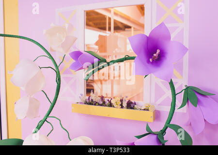 Papier Blumen und Wellpappe auf der Wand Stockfoto