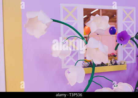 Papier Blumen und Wellpappe auf der Wand Stockfoto
