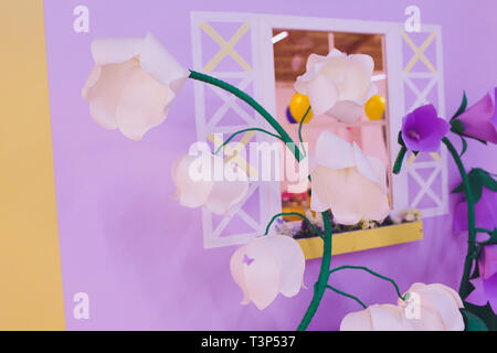 Papier Blumen und Wellpappe auf der Wand Stockfoto