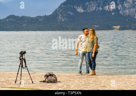 BARDOLINO, Gardasee, Italien - September 2018: Mann und Frau ein Bild von sich selbst Küssen am Rande des Gardasees. Stockfoto