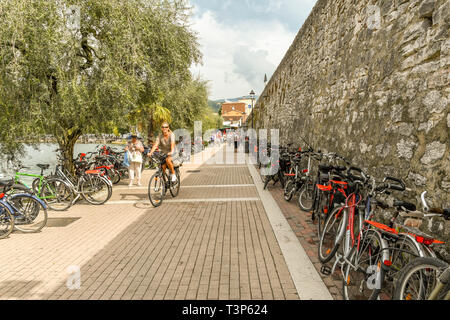 GARDA, Gardasee, Italien - September 2018: Reihe von Fahrrädern gegen eine Wand an der Promenade in Garda am Gardasee geparkt. Stockfoto