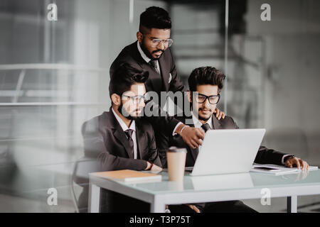 Teamwork Konzept. jungen Mitarbeiter arbeiten mit neuen Business Projekt in modernen Büro. Gruppe von drei Personen, Daten, die auf Notebook Computer analysieren. Stockfoto