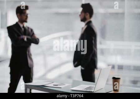 Zwei lächelnde Geschäftsmänner gemeinsam diskutieren, während die von Windows stehen in einem Büro Stockfoto