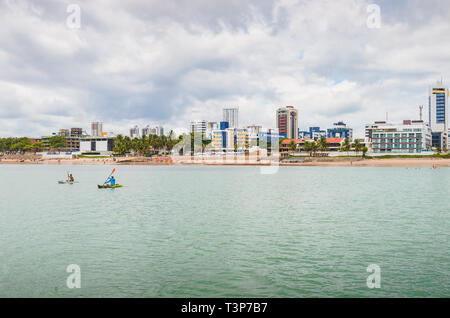 Joao Pessoa - PB, Brasilien - 21. Februar 2019: Touristen reiten Kajak- und der Praia do Bessa Strand und der Stadt Joao Pessoa für den Hintergrund. Stockfoto