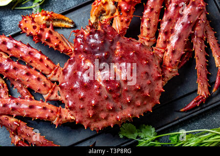 Red king crab auf grauem Hintergrund. King Crab, Zitrone und Koriander, Ansicht von oben Stockfoto