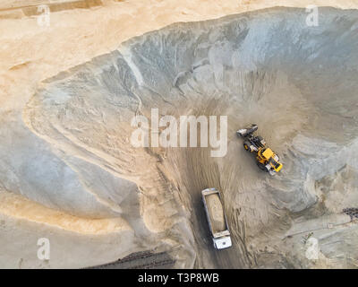 Große schwere Radlader laden Sand in die Dump Truck im Sandkasten. Industriemaschinen Konzept Stockfoto