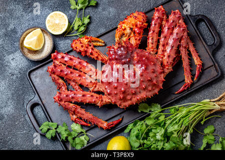 Red king crab auf grauem Hintergrund. King Crab, Zitrone und Koriander, Ansicht von oben Stockfoto