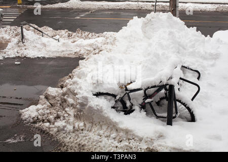 Fahrrad und Gestell sind in einem Haufen Schnee am Smith College in Northampton, Massachusetts. Stockfoto