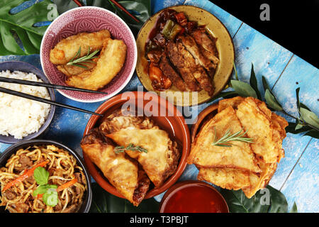 Verschiedene chinesische Gerichte. Chinesische Nudeln, gebratener Reis, Pekingente, Dim Sum, Frühlingsrollen. Berühmte chinesische Gerichte auf den Tisch. Chinesisches Restaurant Stockfoto