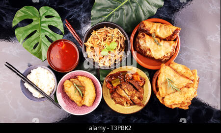 Verschiedene chinesische Gerichte. Chinesische Nudeln, gebratener Reis, Pekingente, Dim Sum, Frühlingsrollen. Berühmte chinesische Gerichte auf den Tisch. Chinesisches Restaurant Stockfoto