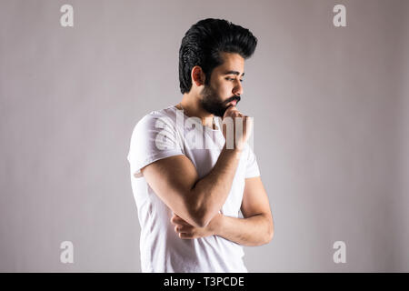 Jungen gutaussehenden Mann trägt blaue T-Shirt über isolierte Hintergrund Schmerzen an den Händen und Fingern, Arthritis Entzündung Stockfoto