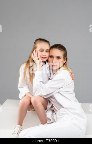 Angenehm nach Frau sitzt mit ihrer jüngeren Schwester und vorsichtig berühren. Stockfoto