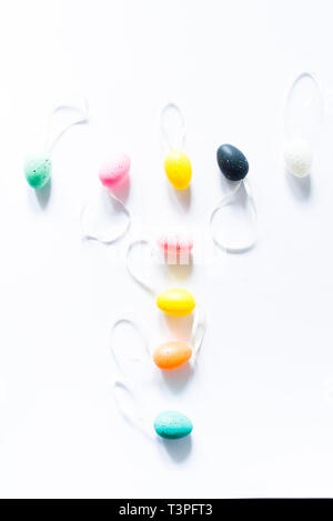 Bunte kleine Eier auf einem weißen Hintergrund angeordnet die Buchstaben t, Feiertag Ostern Konzept Stockfoto