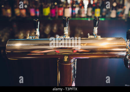 Die Theke mit Flaschen und Vorrichtung zum Dosieren von Bier. Vorrichtung zum Dosieren von Bier an der Bar. Pub. Die Bar im Restaurant. Geräte Stockfoto