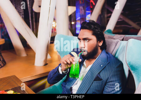 Zwei Mann in Bar halten Gläser Sitzen an der Theke, Trinken Cocktail, fröhliche Freunde treffen Bar zu sprechen. Stockfoto