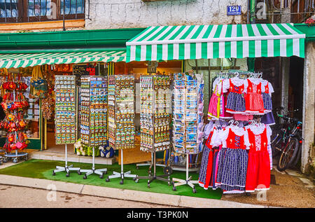 HALLSTATT, Österreich - 21. FEBRUAR 2019: Die Stände mit Magneten, Postkarten, Trachten und andere Souvenirs Vor dem touristischen Geschäft, auf März Stockfoto