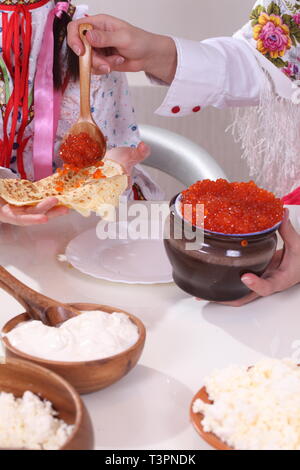 Weibliche hand Kaviar auf Pfannkuchen Stockfoto