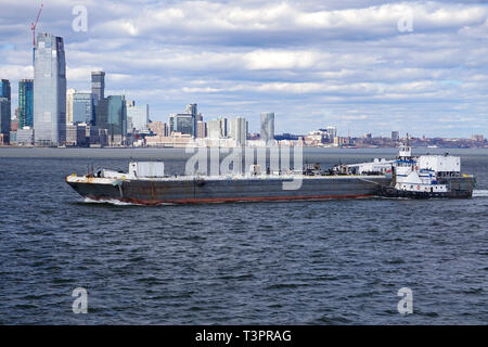 Tugboat drücken ein Schiff in den Hafen von New York Stockfoto