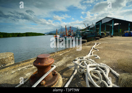 In der Nähe von Hafen Poller mit Liegeplatz Seile und bunten Fischerbooten Hintergrund. Kuraburi Port. Thailand Stockfoto