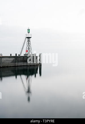 Der Hafen Mole in Rorschach Hafen auf einem typischen April Frühling Morgen am Bodensee in der Schweiz. Lange Belichtung mit vielen negativen Raum. Stockfoto