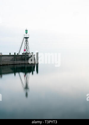 Der Hafen Mole in Rorschach Hafen auf einem typischen April Frühling Morgen am Bodensee in der Schweiz. Lange Belichtung mit vielen negativen Raum. Stockfoto