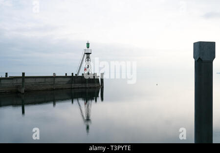 Der Hafen Mole in Rorschach Hafen auf einem typischen April Frühling Morgen am Bodensee in der Schweiz. Lange Belichtung mit vielen negativen Raum. Stockfoto