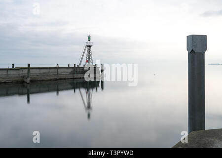 Der Hafen Mole in Rorschach Hafen auf einem typischen April Frühling Morgen am Bodensee in der Schweiz. Lange Belichtung mit vielen negativen Raum. Stockfoto