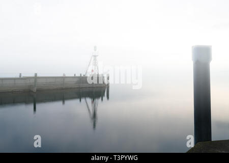 Der Hafen Mole in Rorschach Hafen auf einem typischen April Frühling Morgen am Bodensee in der Schweiz. Lange Belichtung mit vielen negativen Raum. Stockfoto