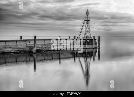 Der Hafen Mole in Rorschach Hafen auf einem typischen April Frühling Morgen am Bodensee in der Schweiz. Lange Belichtung mit vielen negativen Raum. Stockfoto