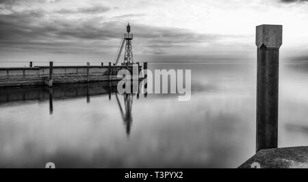 Der Hafen Mole in Rorschach Hafen auf einem typischen April Frühling Morgen am Bodensee in der Schweiz. Lange Belichtung mit vielen negativen Raum. Stockfoto