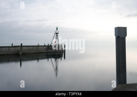 Der Hafen Mole in Rorschach Hafen auf einem typischen April Frühling Morgen am Bodensee in der Schweiz. Lange Belichtung mit vielen negativen Raum. Stockfoto