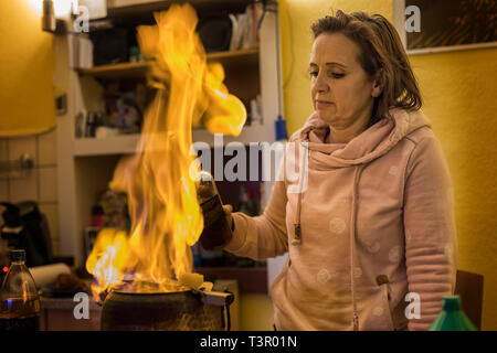 Frau bereitet ein Feuer Zangen Punch (Feuerzangenbowle) vor, entsprechend einer alten deutschen Rezept Stockfoto