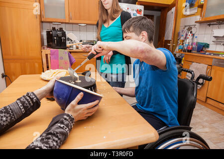 Familie mit behinderten Sohn backt Waffeln Stockfoto