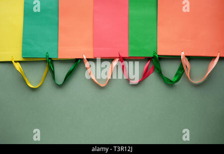 Blick von oben auf die Papier Einkaufstüten mit Griffen auf grünem Hintergrund. Mockup für Design. Flach Stockfoto