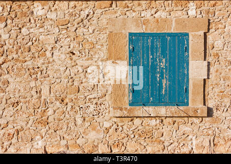 Antike Mauer aus Stein und blauen Fensterläden aus Holz. Traditionelle vintage Nussbaum, Zyperns im europäischen Stil Stockfoto