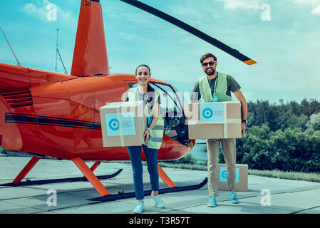 Aktive fröhliche Jungs, professionelle Helfer und über ihre Erfahrungen Stockfoto
