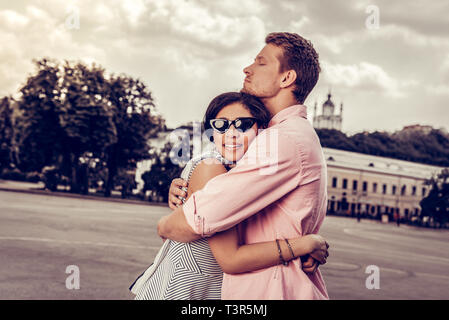 Angenehmes nettes junges Paar umarmen einander Stockfoto