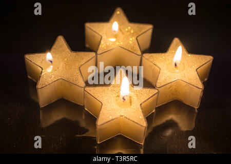 Vier Sterne geformte Kerzen wurden angezündet für den vierten Advent Stockfoto