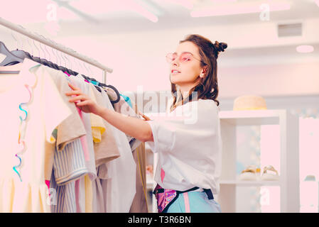 Junge Frau Wahl helle Kleidung im Shop Stockfoto