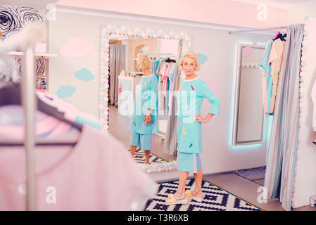 Frau mittleren Alters gerade helle Kleidung im Shop Stockfoto