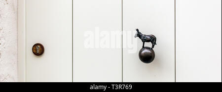 Scharf weiße Holztür mit Esel geformte Messing Türknopf oder in einem der mittelalterlichen Stadt Brügge Häuser in Belgien. Vintage dekorative Türgriff Stockfoto